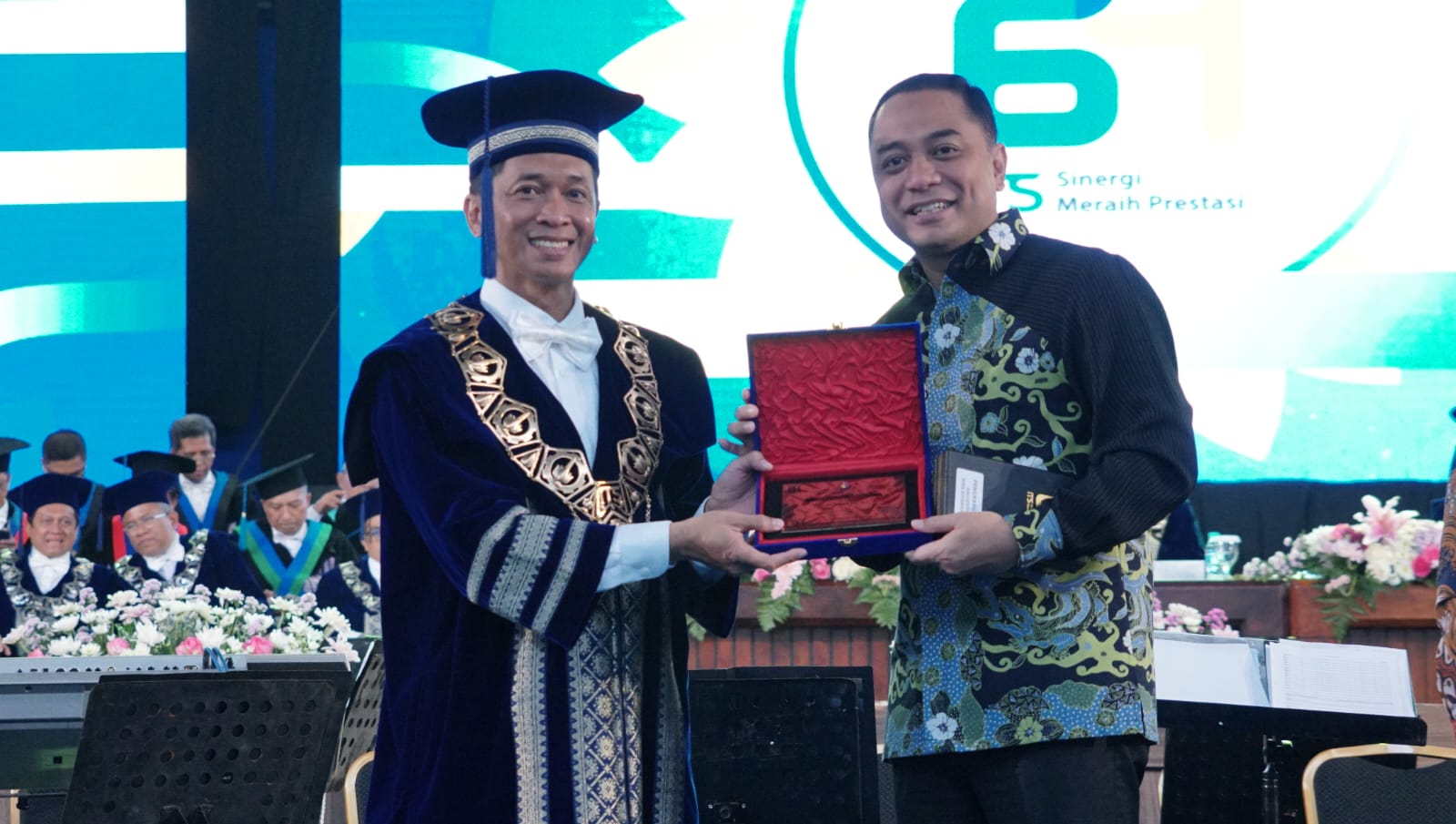 Rektor ITS Prof Ir Bambang Pramujati ST MScEng PhD (kiri) saat menyerahkan penghargaan kepada mantan Wali Kota Surabaya Dr Eri Cahyadi ST MT di acara Puncak Dies Natalis ke-64 ITS