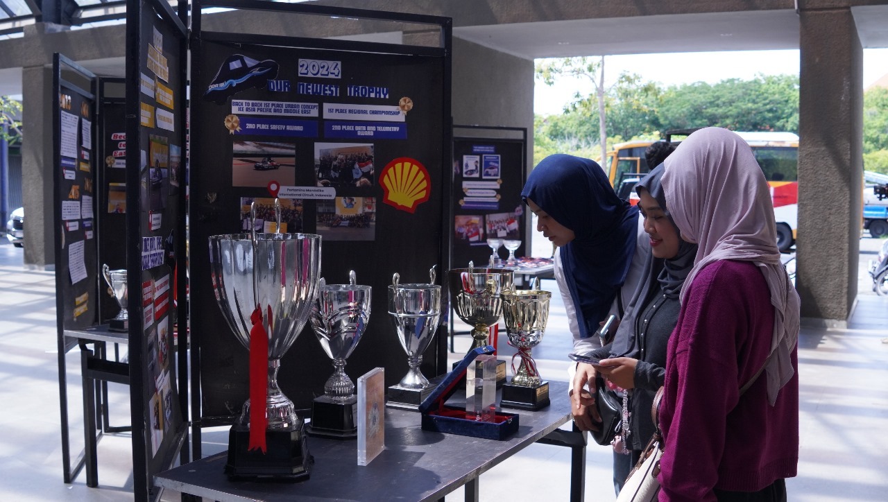 Tiga Mahasiswa ITS saat mengunjungi Exhibition yang menampilkan berbagai piala dan medali dari tim Sapuangin ITS