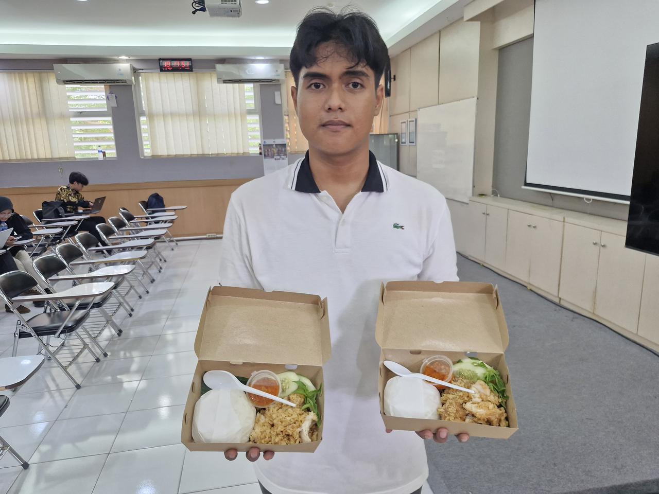 Bima Saputra menunjukkan nasi ayam geprek jualannya yang dikenal murah meriah di kalangan mahasiswa ITS