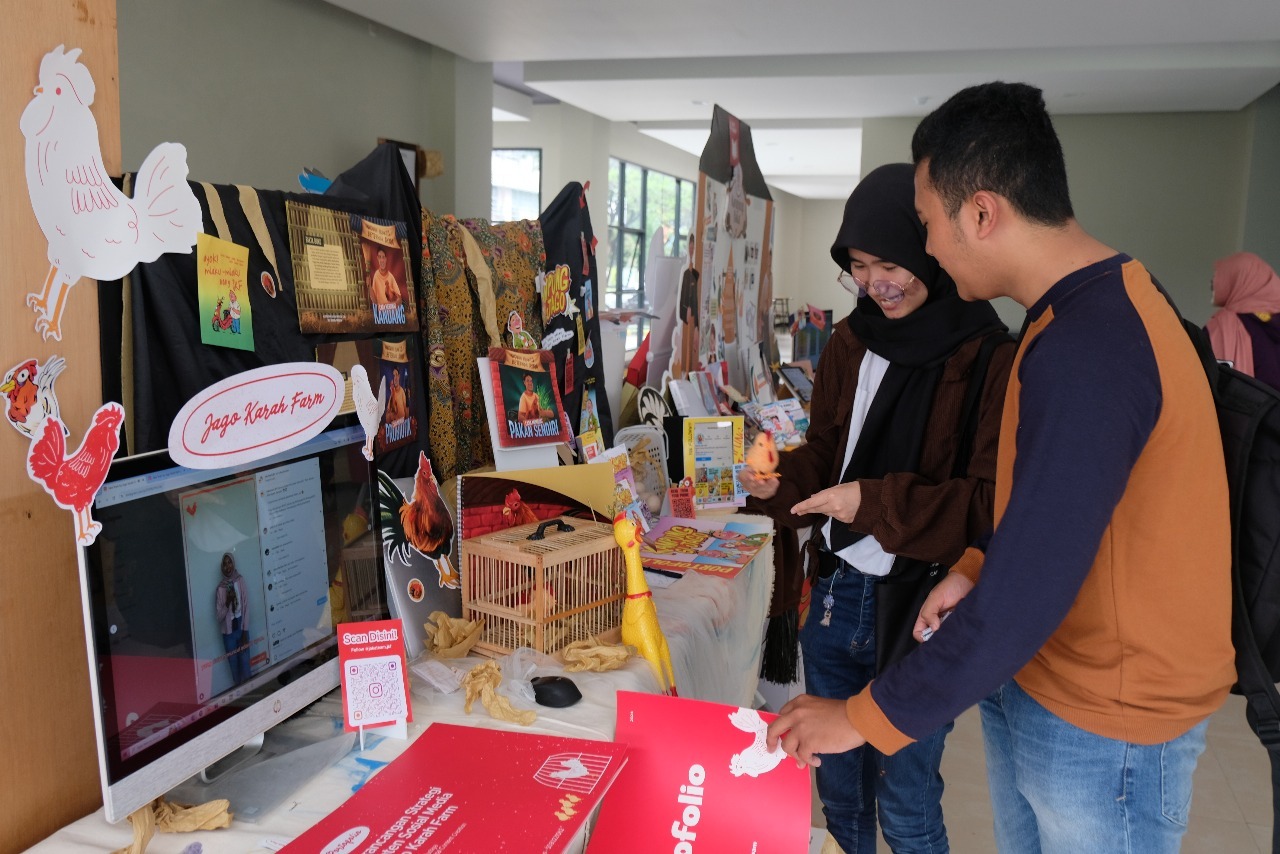 Mahasiswa ITS yang mengunjungi salah satu booth yang manampilkan desain konten promosi komunitas peternak ayam