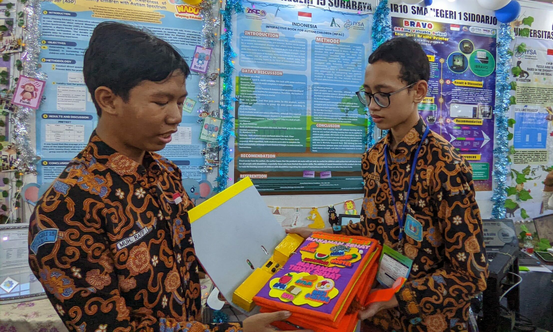 Gambar Demonstrasi dari Tim SMA Negeri 15 Surabaya menampilkan buku interaktif mereka, yang berfungsi untuk mendorong kemandirian anak-anak dengan autisme.