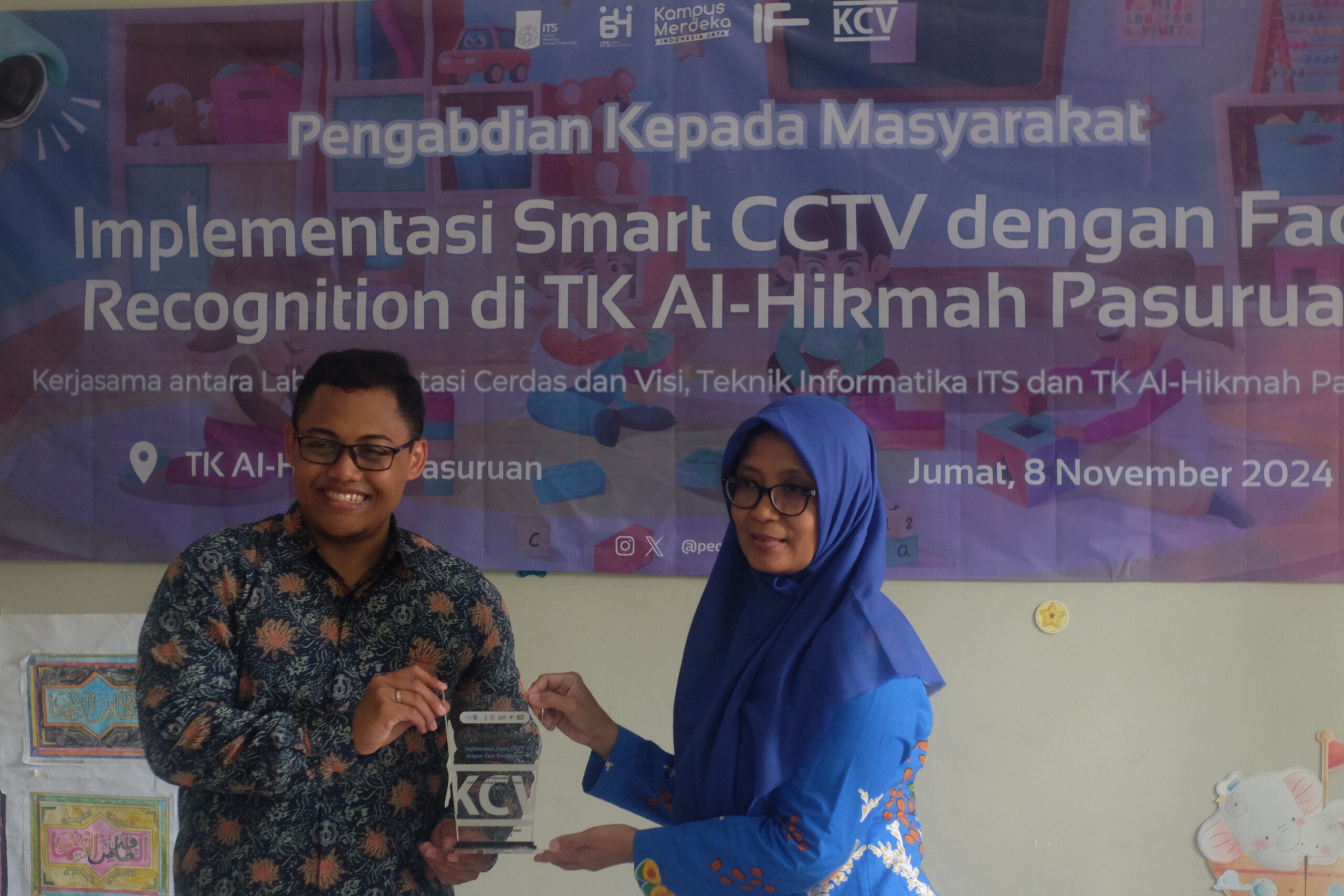 Aldinata Rizky Revanda SKom Mkom (kiri) menyerahkan plakat pelatihan bertema “Implementasi Smart CCTV dengan Face Recognition” pada Kepala Sekolah TK Al-Hikmah Pasuruan