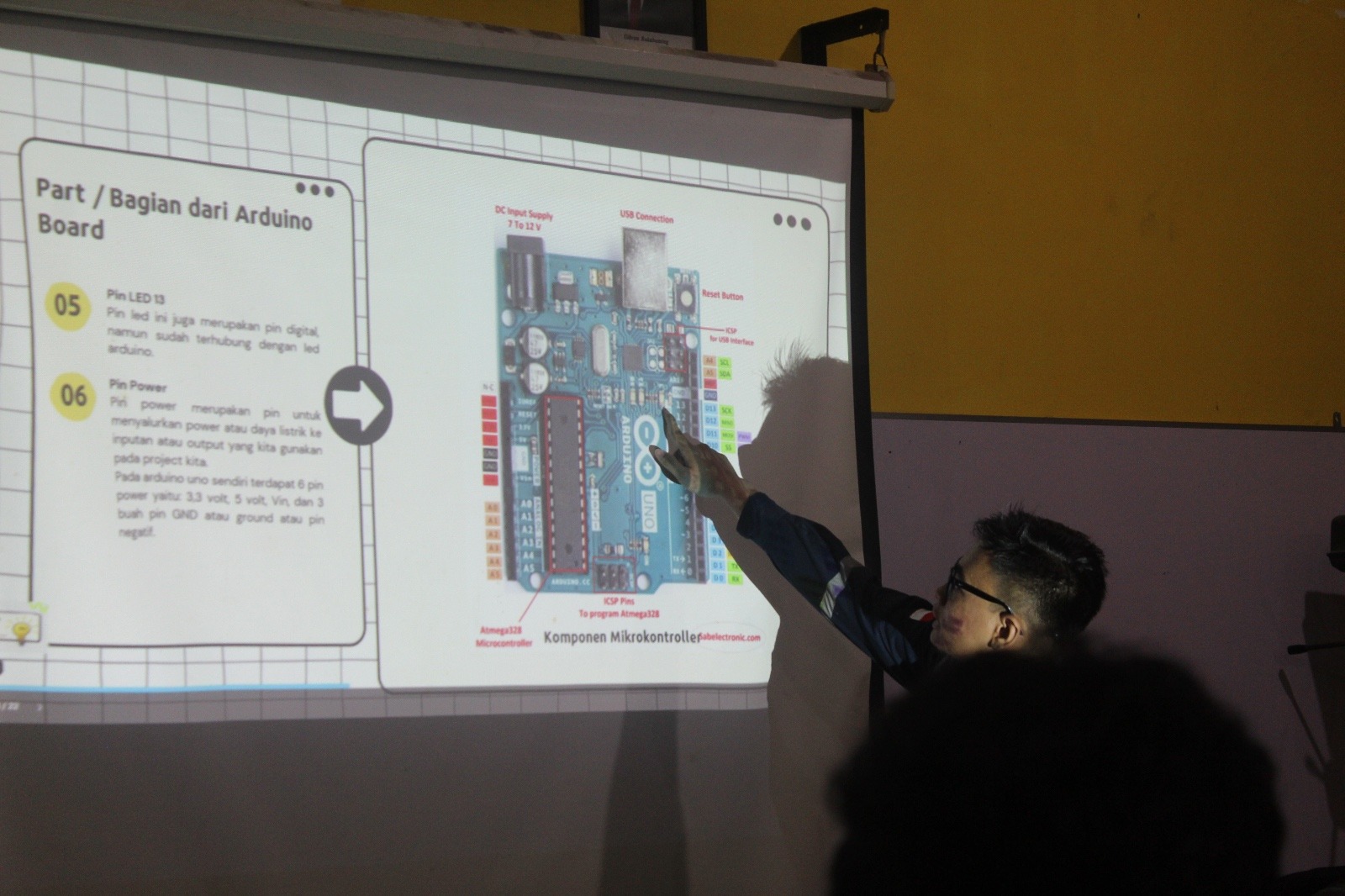 Mahasiswa KKN Abmas memberikan penjelasan materi terkait bagian Arduino melalui presentasi