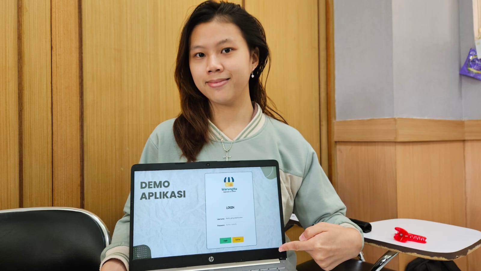 Jenifer Victoria Jaya Andreas, salah satu anggota tim KKN Abmas ITS, menunjukkan tampilan demo aplikasi WarungKu