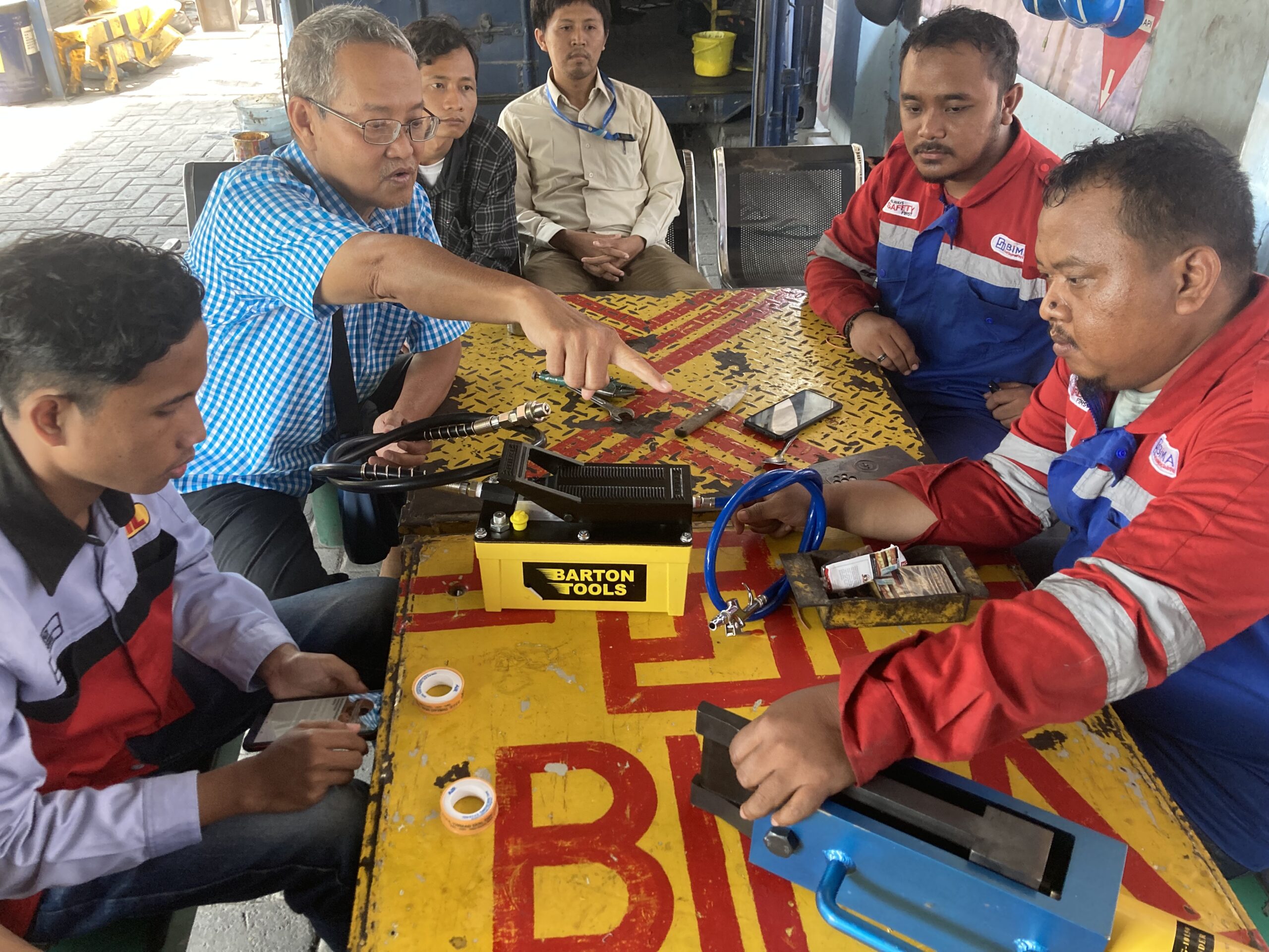 Ketua tim KKN ITS Ir Arino Anzip MEng Sc (dua dari kiri) dan tim KKN saat menjelaskan alat pengganti pelek ban RTG portabel kapada teknesi dari PT BIMA