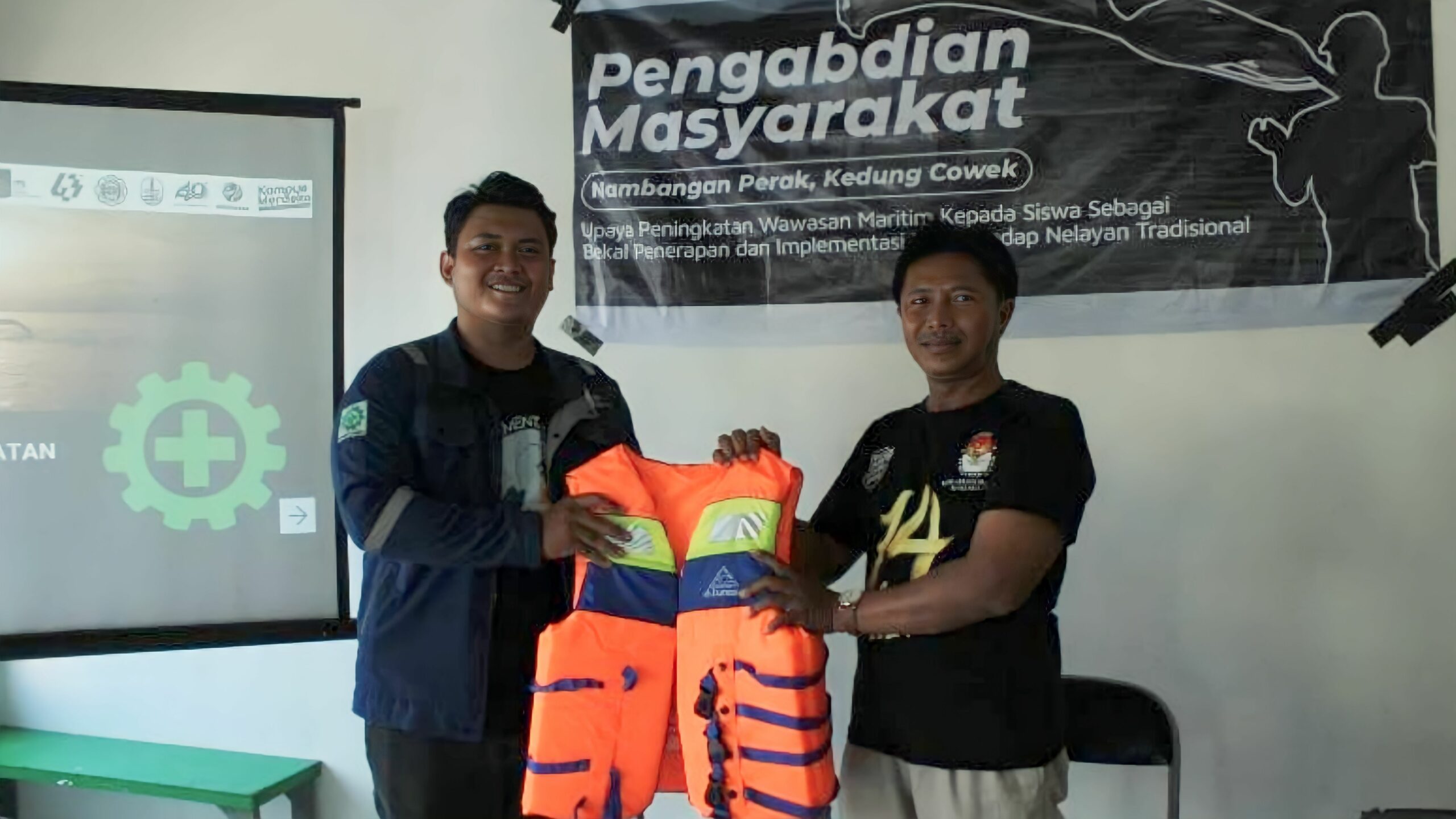 Tim KKN Abmas ITS memberikan rompi pelampung