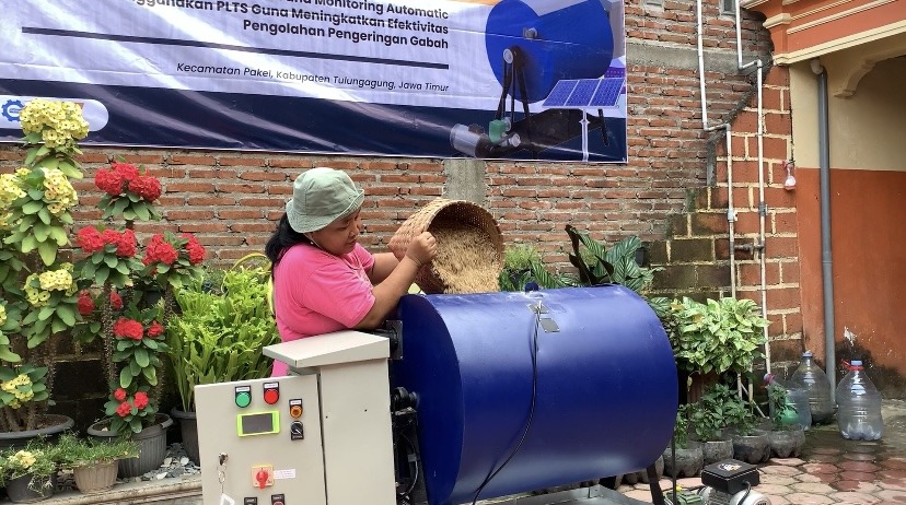 Salah satu petani ketika mencoba alat pengering gabah bertenaga surya buatan tim KKN Abmas Departemen Instrumentasi ITS 