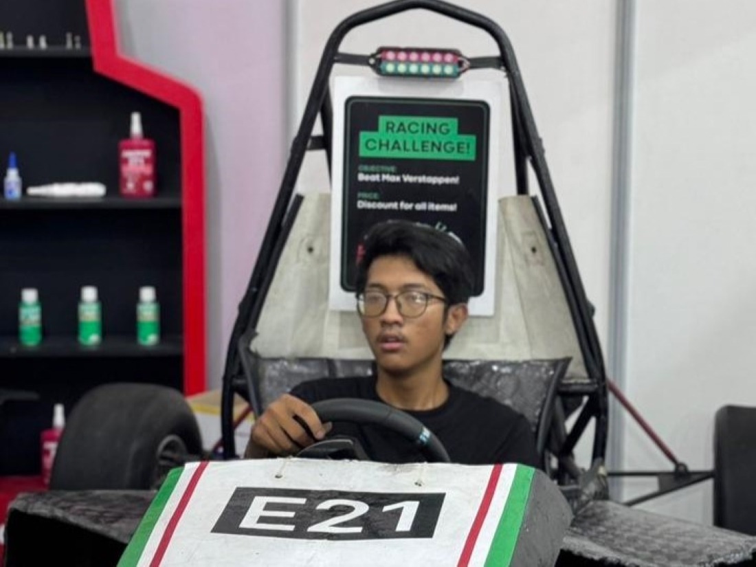 Salah satu pengunjung GIIAS 2024 yang mencoba simulator mobil Formula 1 di dalam chassis Anargya Formula EV Mark 3.0 yang dipamerkan oleh Tim Anargya ITS