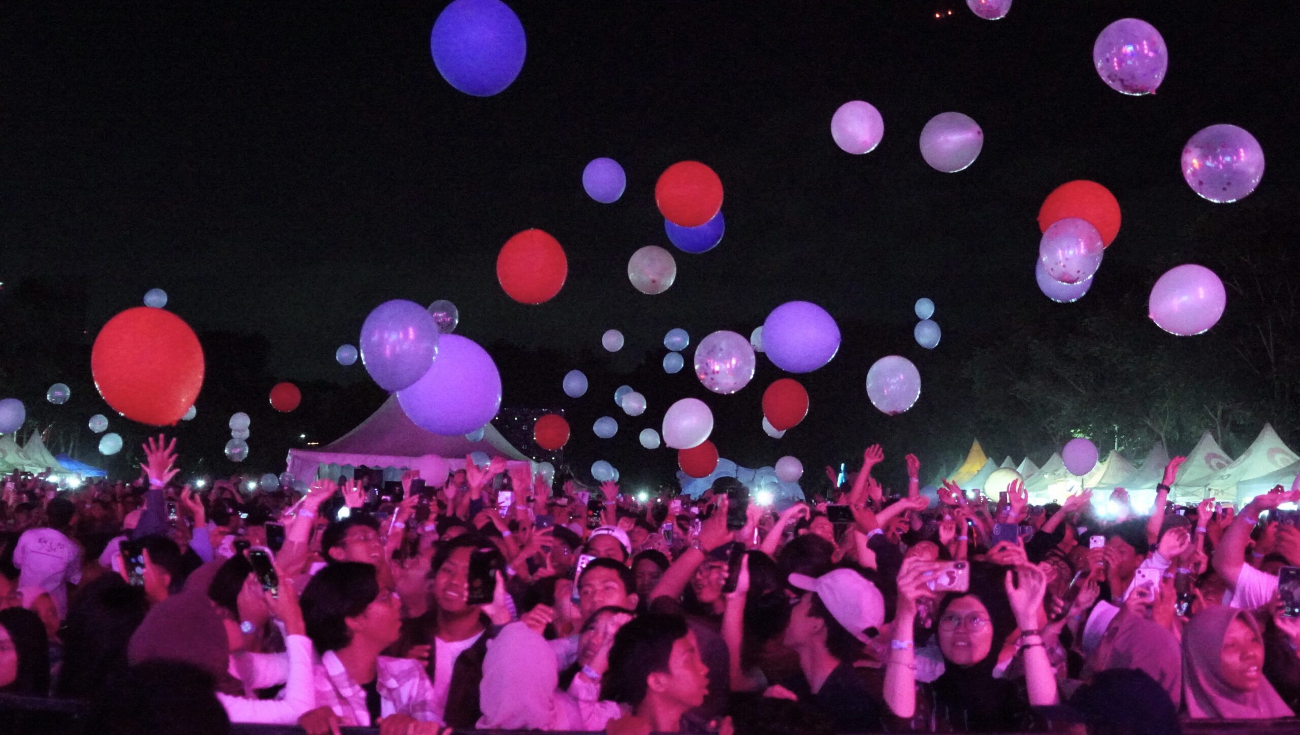 Kegembiraan para penonton saat bermain balon warna-warni yang mengiringi lagu Is It The Answer pada malam puncak UKM Expo 2024