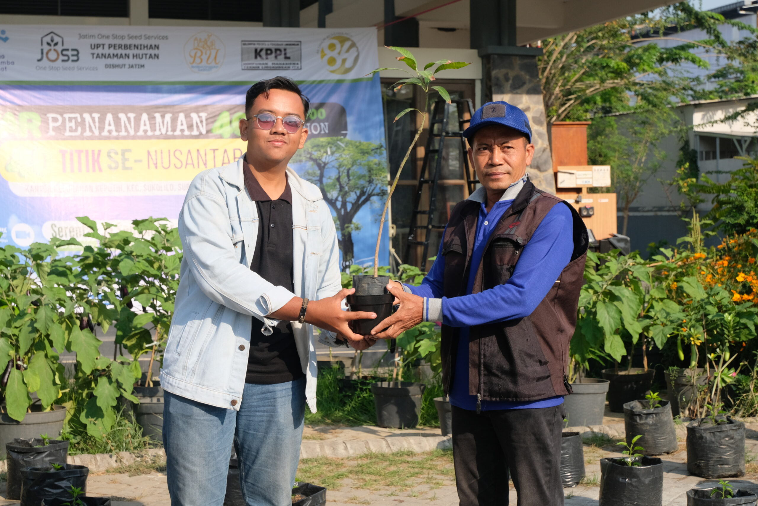 Foto penyerahan bibit pohon dari Ketua Paguyuban KSE ITS (kiri) kepada perwakilan dari Kelurahan Keputih (kanan)