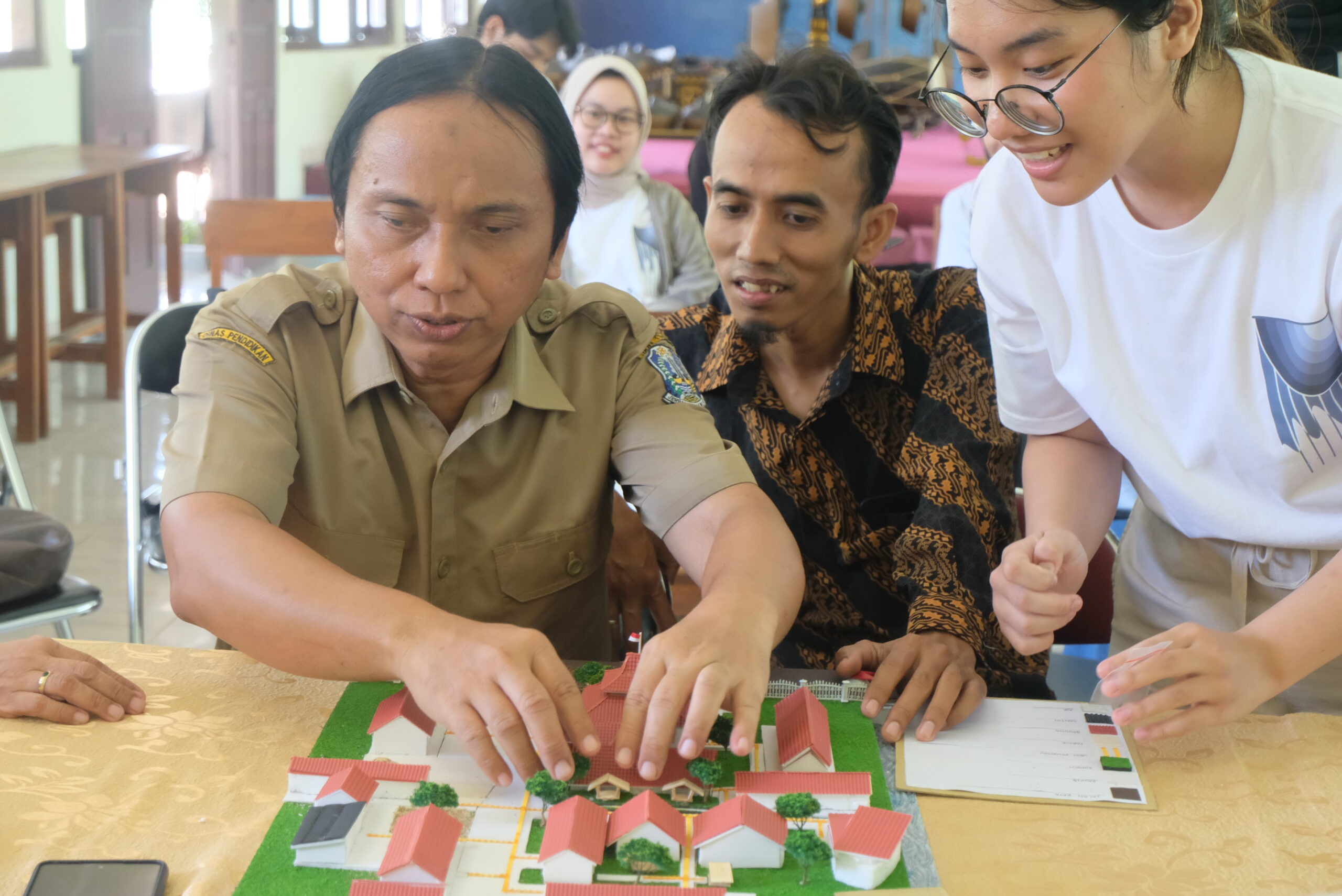 Guru Netra YPAB Atung Yunarto MPd saat meraba maket masterplan oleh tim KKN Abmas ITS