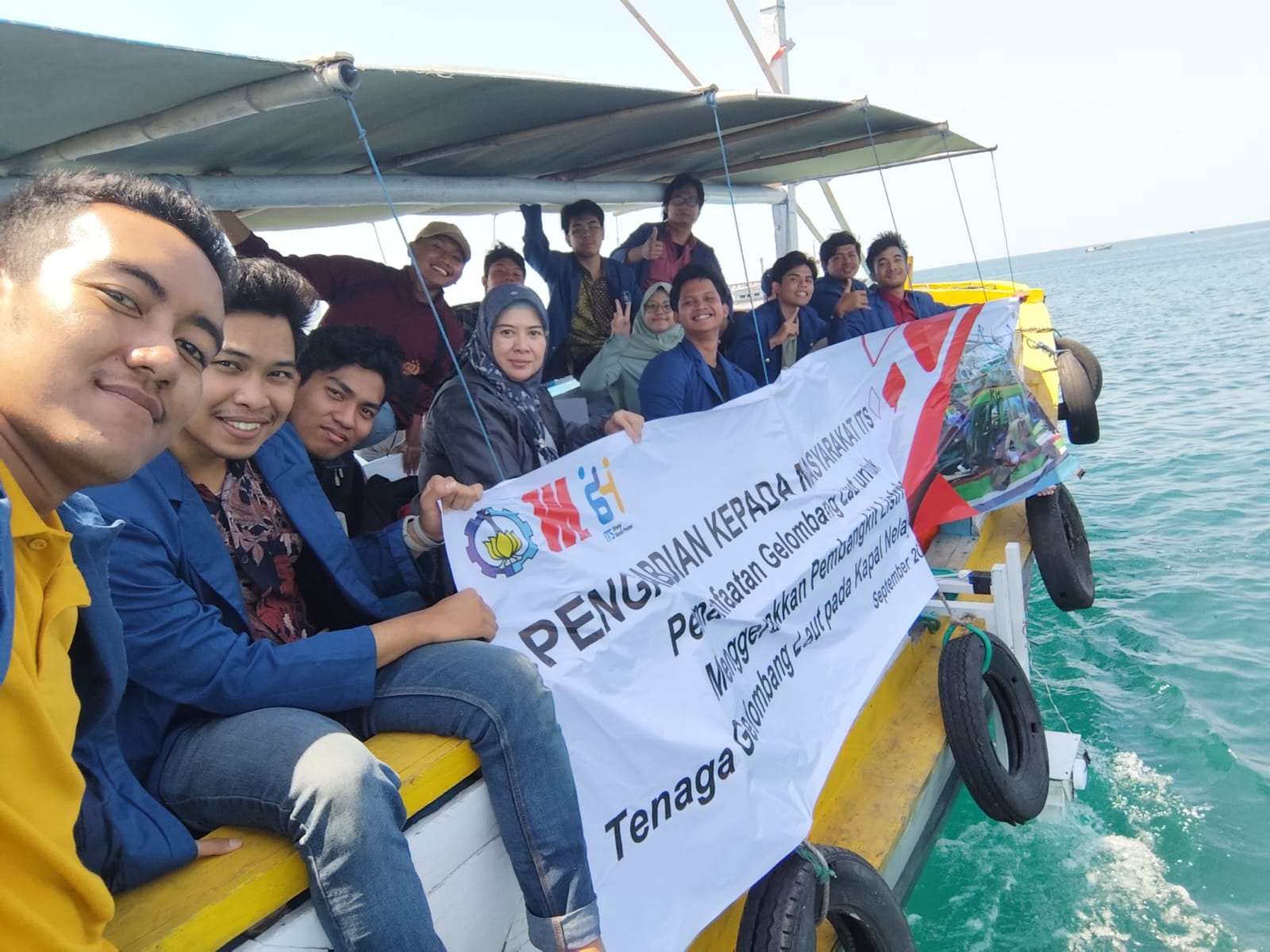 Gambar anggota tim KKN Abmas ITS bersama Prof Dr Wiwiek Hendrowati ST MT (empat dari kiri) duduk di atas kapal nelayan mitra usai pemasangan PLTGL pada kapal nelayan mitra